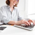 brunette-woman-typing-email-laptop-computer-while-sitting-home-selective-focus-hand